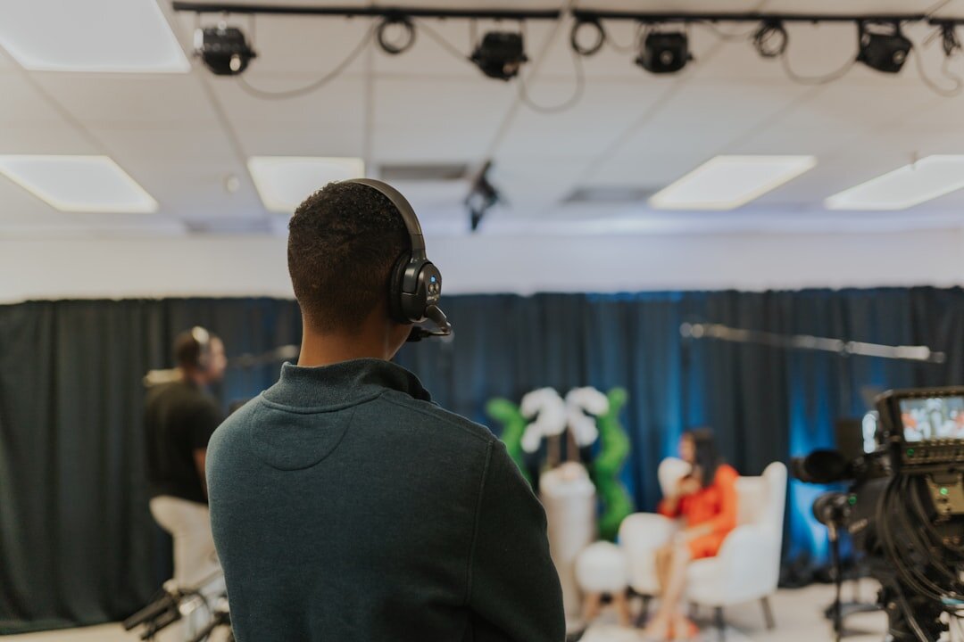 Video production crew filming a corporate speaker in a studio
